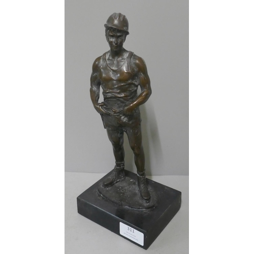 311 - A bronze figure of a miner, on black marble socle