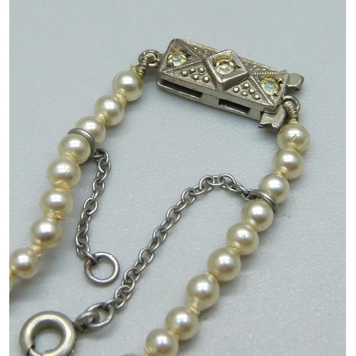 1041 - A string of cultured pearls with diamond set white metal clasp