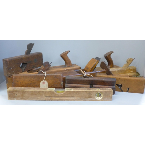 735 - Seven woodworking planes and a level