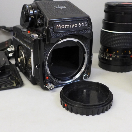 739 - A Mamiya 645 1000s medium format film camera with three lenses; 210mm, 150mm, 80mm, a range of filte... 