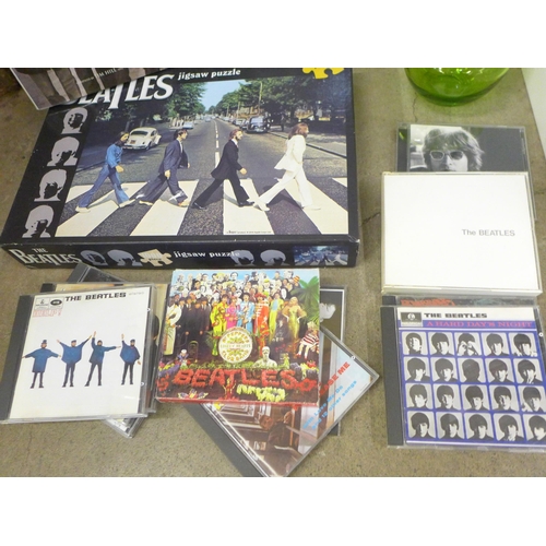 780 - A collection of The Beatles memorabilia including CDs (11), book, jigsaw puzzle, a glass apple and a... 