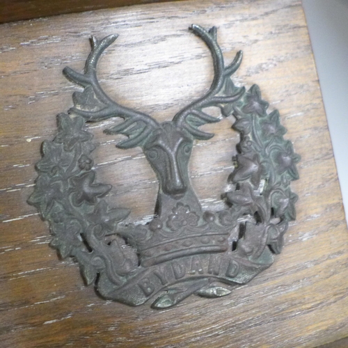 824 - An oak pipe rack, 51st Highlanders with five applied badges