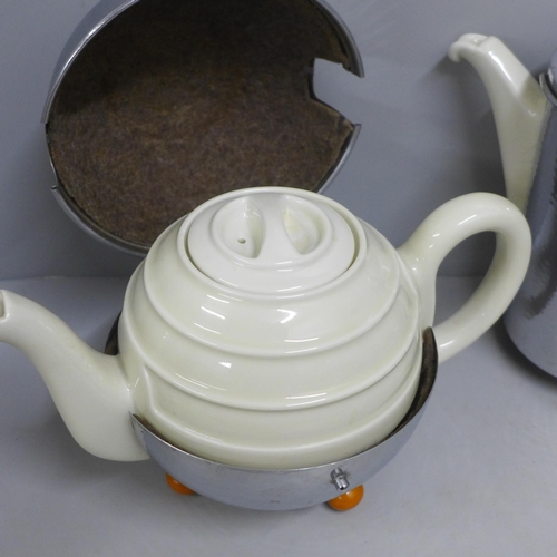 826 - A planished steel covered tea pot and hot water jug