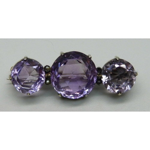 957 - A brooch set with three amethysts and seed pearls and one other brooch, (lacking one seed pearl)