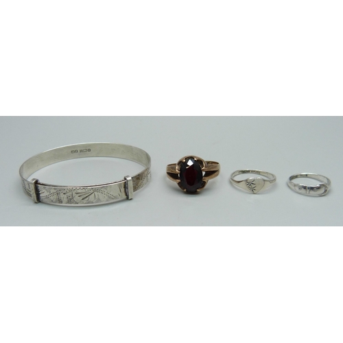 987 - A 9ct gold ring set with a garnet, 4g, Q, a silver child's bangle and two small silver child's size ... 