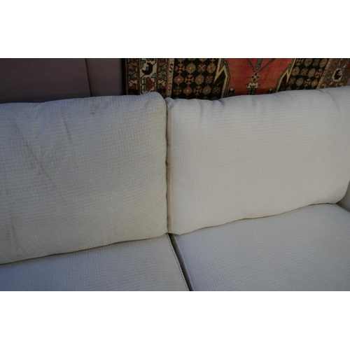 1541 - A cream upholstered three seater sofa with steel trim - differing fabric batches on each section