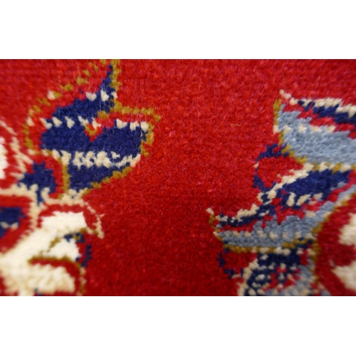 1549 - A rich red ground Cashmere carpet, full pile, floral medallion design, 200cm x 300cm