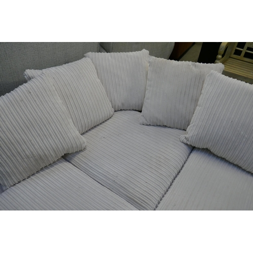 1596 - A white jumbo cord corner sofa and ottoman footstool (damaged)