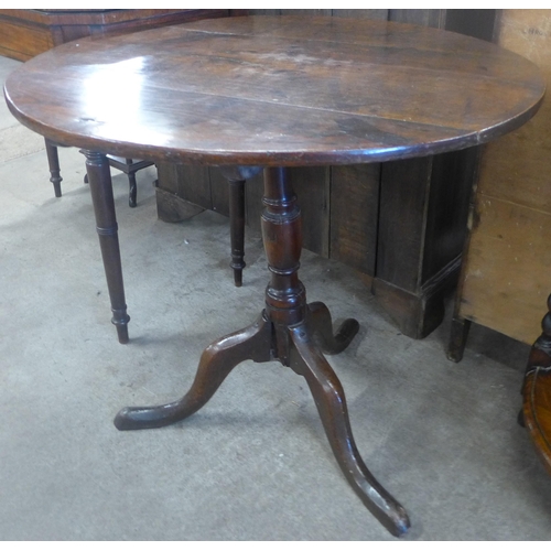 133 - A George III oak circular tilt top tripod tea table