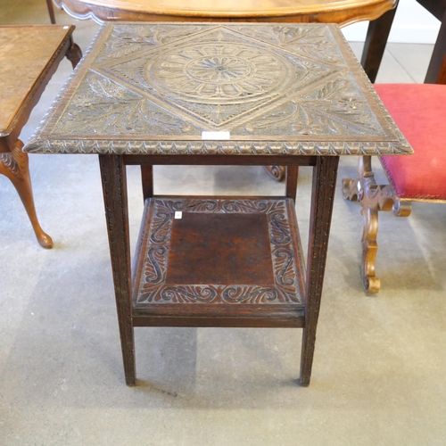 151 - A Victorian Jacobean Revival carved oak two tier occasional table