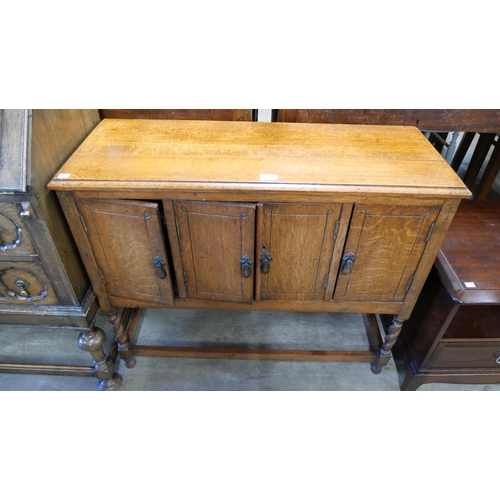 195 - An early 20th Century oak barleytwist four door livery cupboard