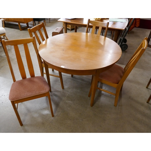 3 - A circular teak extending dining table and four chairs