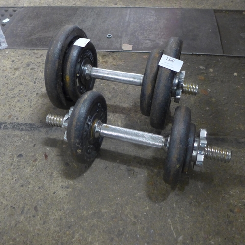 2380 - A set of cast iron bar bell weights including two 5kg plates, four 2.5kg plates and two 0.5kg plates