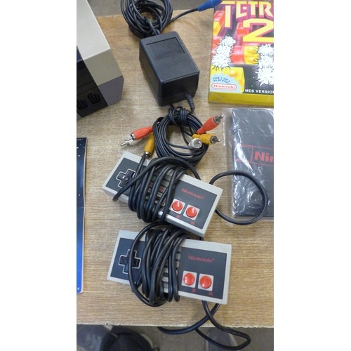 2125 - A Nintendo Entertainment System (NES) console with four game cartridges including Super Mario/Duck h... 