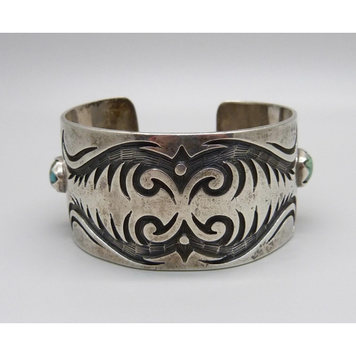 1030 - A silver and stone set bangle, marked sterling, Navajo style