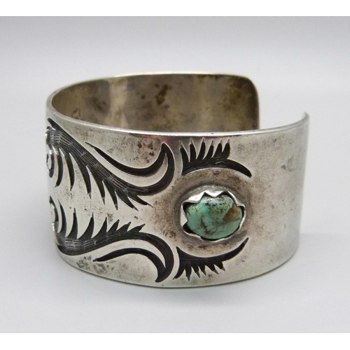 1030 - A silver and stone set bangle, marked sterling, Navajo style