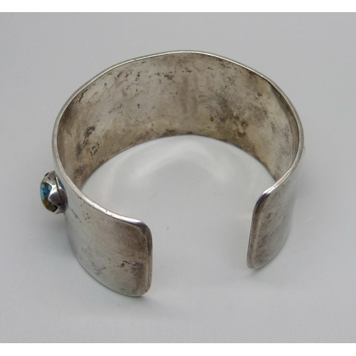 1030 - A silver and stone set bangle, marked sterling, Navajo style