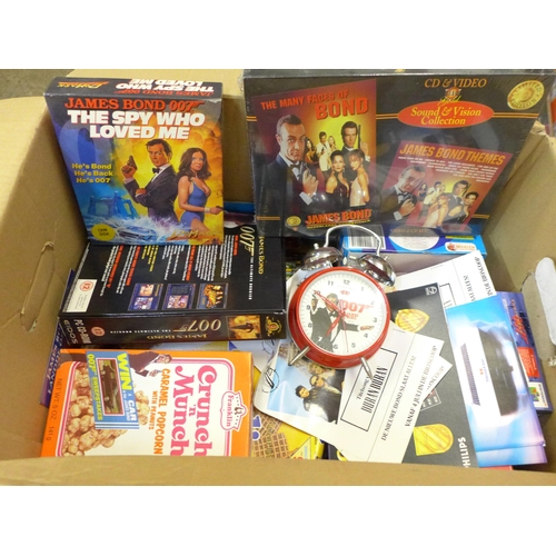 730 - A James Bond Collection including clock, flyers, games, cereal packets, VHS/CD sets, etc.