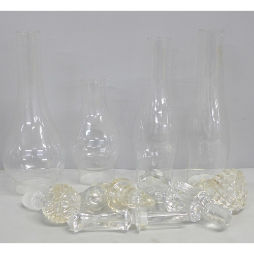 763 - A collection of crystal and glass decanter stoppers and four glass oil lamp shades