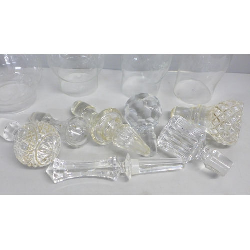 763 - A collection of crystal and glass decanter stoppers and four glass oil lamp shades