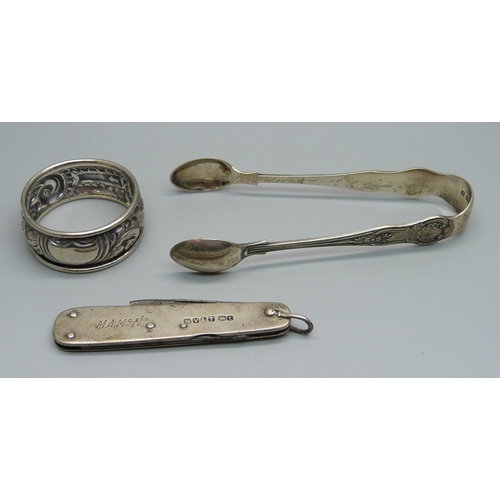 852 - A silver napkin ring, a silver handled pocket knife and a pair of silver sugar bows, 37g without poc... 