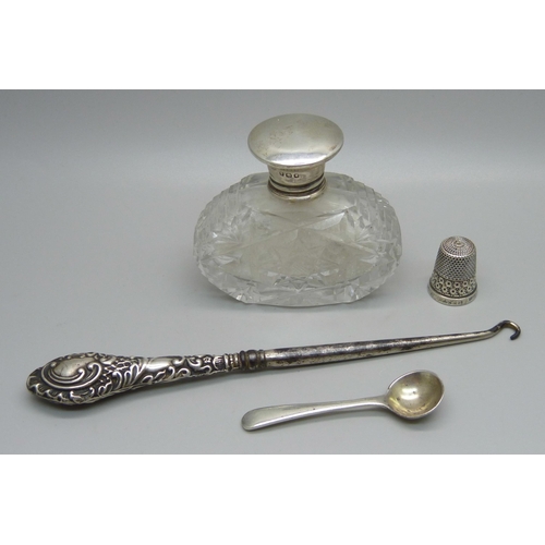 862 - Silver items; salt spoon, thimble, silver topped scent bottle and a button hook, neck of glass scent... 