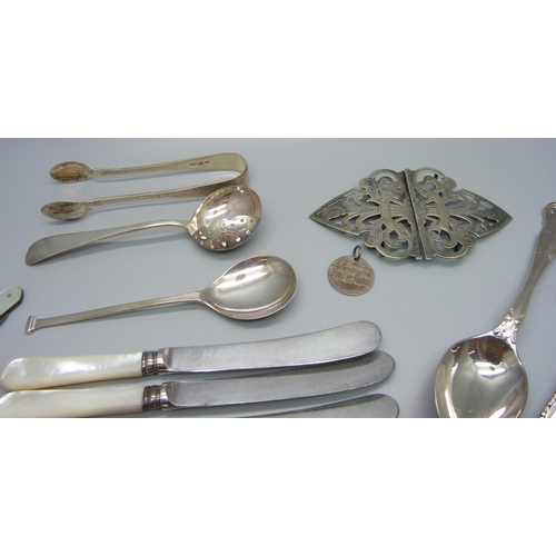 879 - Four silver spoons, a pair of silver sugar bows, two silver and mother of pearl fruit knives, a plat... 