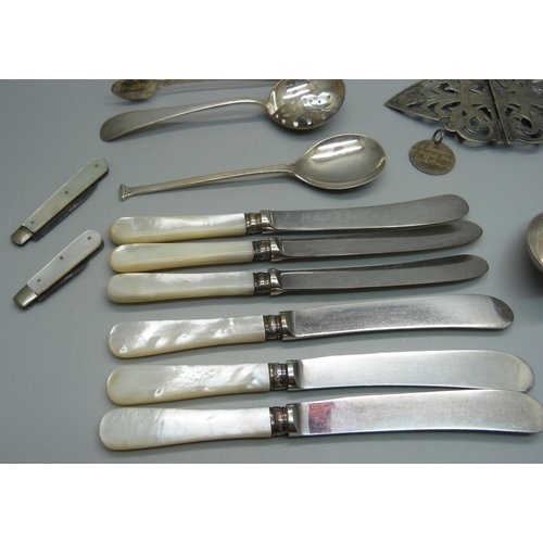 879 - Four silver spoons, a pair of silver sugar bows, two silver and mother of pearl fruit knives, a plat... 