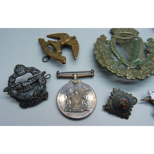 885 - A Regiment President Kruger military badge, a large Irish regimental badge, a South Africa For War S... 