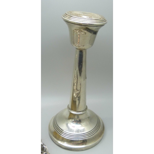 902 - Two silver candlesticks, a silver backed mirror and a silver brush