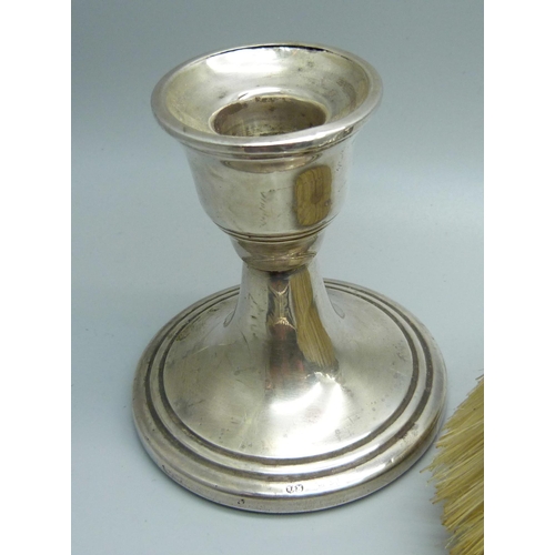 902 - Two silver candlesticks, a silver backed mirror and a silver brush