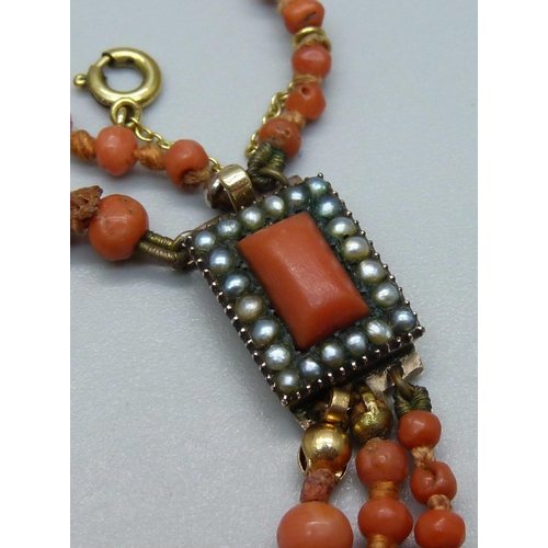 951 - A vintage three strand coral necklace with pearl set yellow metal clasp, 62.4g