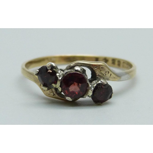 957 - A 9ct gold and three stone garnet ring, 1.6g, Q, centre stone replaced