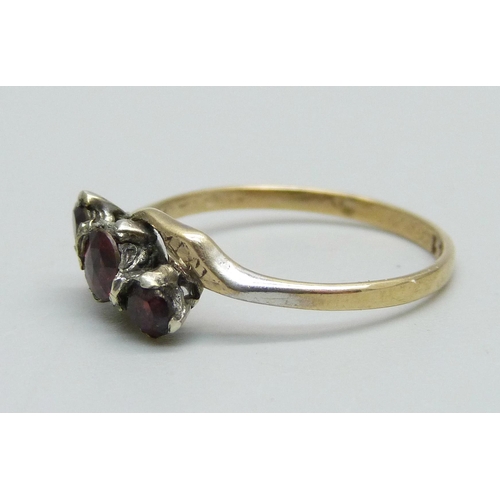 957 - A 9ct gold and three stone garnet ring, 1.6g, Q, centre stone replaced