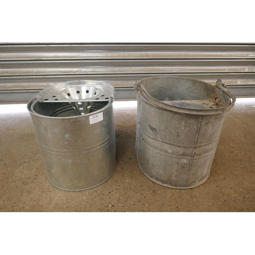 2230 - A galvanised metal watering can, two mop buckets and a Valor paraffin heater