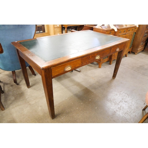 140 - An early 20th Century oak three drawer library table