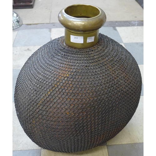 202 - A large eastern chain wrapped brass bottle shaped vessel