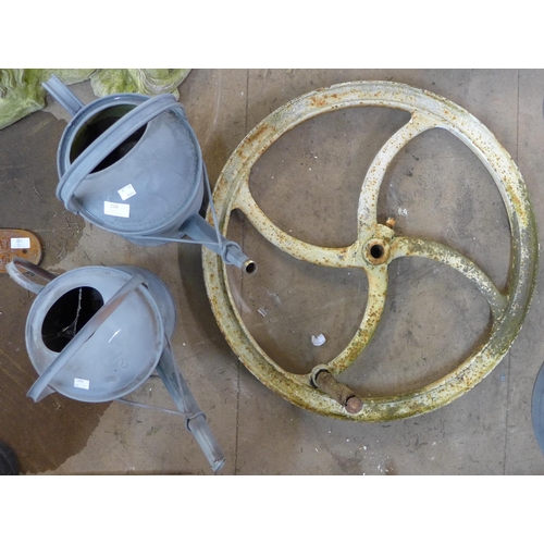 210 - A cast iron wheel crank and two galvanised watering cans