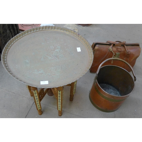 218 - An Islamic brass topped occasional table, a copper and brass coal bucket and a leather Gladstone bag