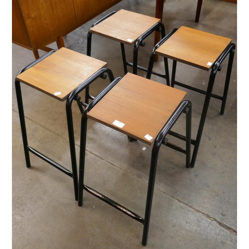 27 - A set of four teak and black tubular metal stools