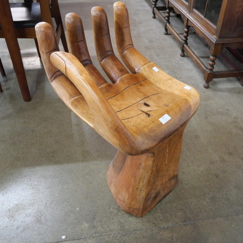 87 - A teak hand shaped seat