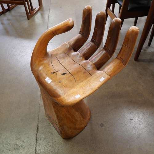 87 - A teak hand shaped seat