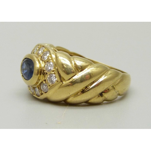 1006 - An 18ct gold, blue stone ring with twelve stone diamond halo, marked 18ct and 750, 8g, M