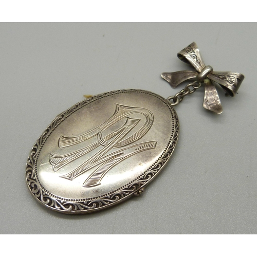 1044 - A vintage silver locket and bow, 8cm, 22g