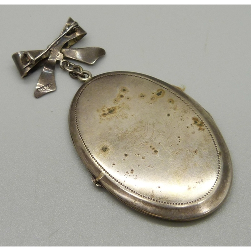 1044 - A vintage silver locket and bow, 8cm, 22g