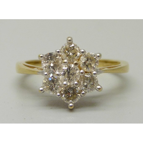 1054 - An 18ct gold, seven stone diamond cluster ring, total brilliant cut diamond weight 1ct, 3.7g, M