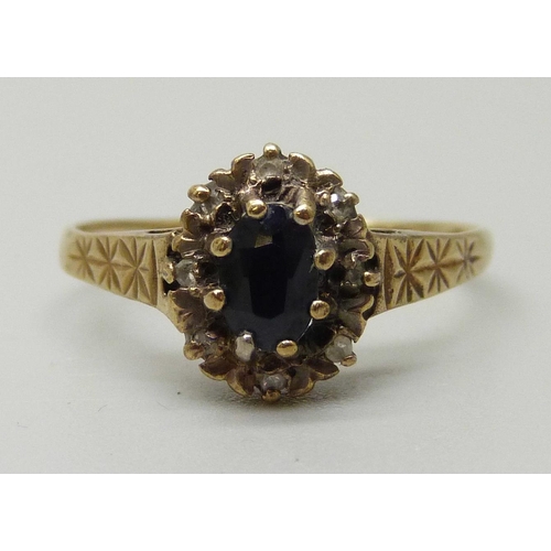 1085 - A 9ct gold cluster ring with central sapphire measuring approximately 0.78ct surrounded by eight dia... 