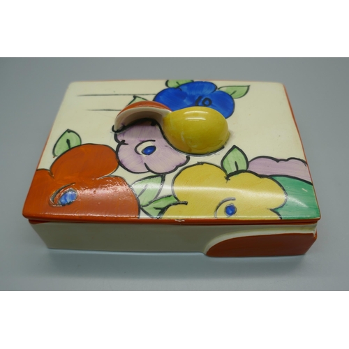 648 - A Clarice Cliff Fantasque lidded pot, 11.5cm wide, star crack to the lid