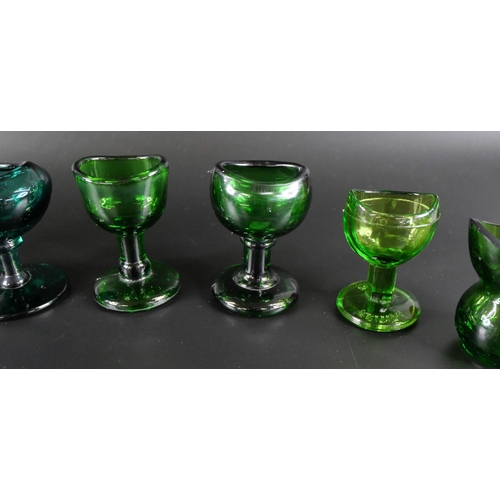 836 - Eight green glass eye baths, some hand blown