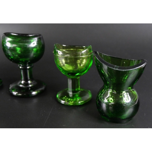 836 - Eight green glass eye baths, some hand blown